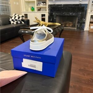 NWT. Stuart Weizmann tennis shoe gold tennis shoe size 6 1/2.